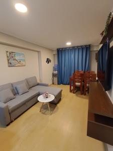 a living room with a couch and a table at Apartment overlooking the water park in Lima