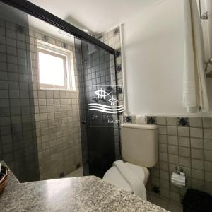 a bathroom with a toilet and a sink and a window at Jatiúca Suítes Resort - Flat 413 in Maceió +43 photos