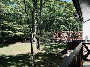 a wooden bridge in a yard next to a tree at Villa Lina - 北軽井沢で四季折々の自然を楽しむプライベート貸別荘 最大6名 in Naganohara