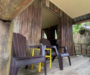 - deux chaises et une table sur la terrasse couverte d'une maison dans l'établissement Moonshine Phayam beach resort & restaurant, à Ranong