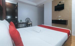a bedroom with a large white bed with red pillows at RedDoorz @ Junquera Extension Cebu in Cebu City