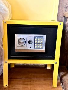 une petite table jaune avec un micro-ondes intégré dans l'établissement Moonshine Phayam beach resort & restaurant, à Ranong