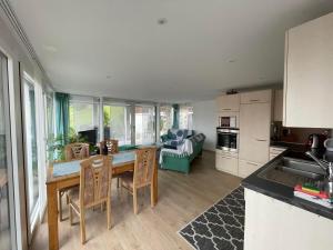 a kitchen and living room with a table and chairs at Ferienwohnung Hälmli in Heiden