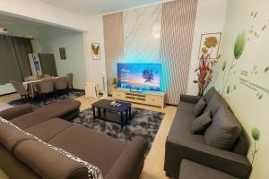 Una sala de estar con dos sofás y un televisor de pantalla plana. en Arlyn's Homestay, en Sandakan