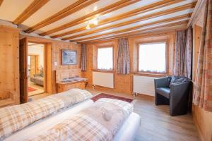 サメーダンにあるChesa Treigのベッド2台と椅子が置かれた部屋