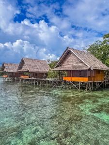 two buildings on the water next to the ocean at THE Drift Wood House in Besir