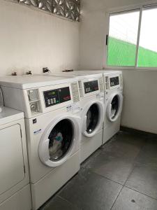three washing machines in a laundry room with a window at Habitacion C10 privada centro monterrey in Monterrey