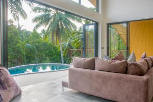 een woonkamer met een bank en een zwembad bij Villa Ocean Breeze in Koh Samui 