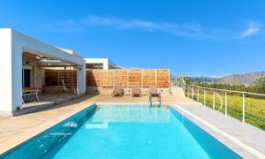 a villa with a swimming pool and a house at Vista Mare Villa Beheizter Pool in Georgioupoli
