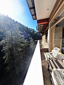 a balcony with chairs and a view of the mountains at Staynest BNB - Balcony Rooms - 3BHK Apartments in Shimla