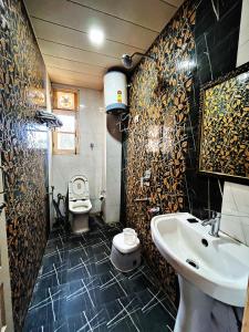 a bathroom with a sink and a toilet in it at Staynest BNB - Balcony Rooms - 3BHK Apartments in Shimla