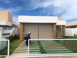 ein Motorrad, das vor einem Haus geparkt ist in der Unterkunft CASA CONDOMINIO COSTA PARADIZO 3 Quartos in Barra dos Coqueiros