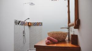 a bathroom with a shower and a bowl on a counter at Angsoka Villas Amed in Amed +30 photos