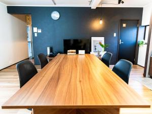 a large wooden table in an office with chairs at Rino-Haku 01 in Anan