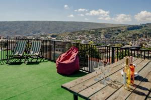 a wooden table with wine glasses on a balcony at Hotel & CoWorking in Tbilisi City