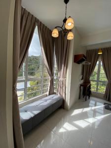 a room with a couch in front of windows at Jo’s Place Cameron Highlands EA922 in Brinchang