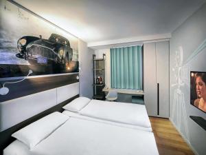 a room with a bed and a picture of a car at ibis Locarno in Locarno +135 photos