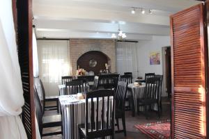 a dining room with tables and chairs and a fireplace at 3 Liebeloft Guest House in Edenvale