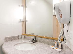 a bathroom with a sink and a phone at ibis Concepcion in Concepción