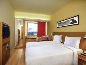 a hotel room with two beds and a television at ibis Bengaluru Hosur Road - An Accor Brand in Bengaluru +85 photos