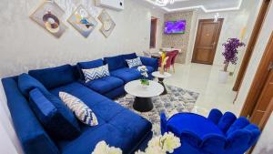 a living room with a blue couch and a table at ELITE Golden Stay - Luxury Apartments in Tangier