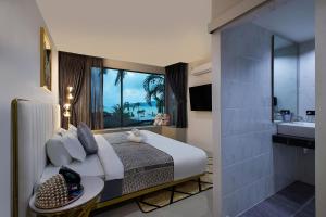 a bedroom with a bed and a bathroom with a sink at Nariya Bayfront Phuket in Chalong +95 photos