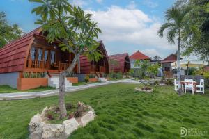 une maison avec un arbre au milieu d'une cour dans l'établissement Bunut Bungalow, à Nusa Penida
