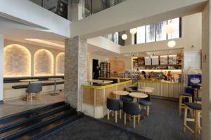 IR-ON Hotel في بانكوك: مطعم به طاولات وكراسي ومنضدة