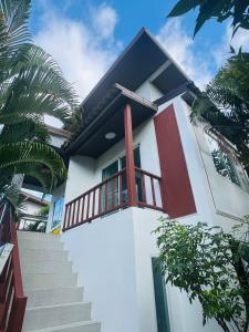 ein Haus, zu dem eine Treppe hinaufführt in der Unterkunft Cozy Villa in the Tropical Garden in Ko Phangan