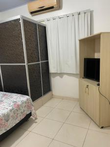 马瑙斯Ana Claudia的一间卧室配有床、电视和窗帘