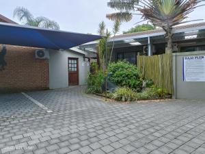 a building with a blue umbrella in front of it at DaaiPlek Holiday home in Richards Bay
