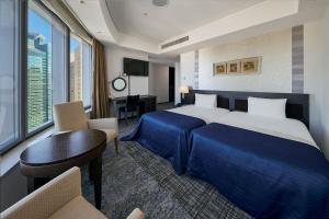 a hotel room with a large bed and a desk at Park Hotel Tokyo in Tokyo