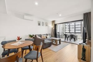 ein Wohnzimmer mit Sofa und Tisch in der Unterkunft Bright 1BR Apartment in the heart of Dickson in Downer