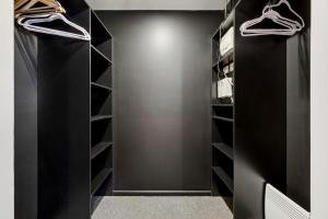 ein schwarzer begehbarer Kleiderschrank mit schwarzen Regalen in der Unterkunft Bright 1BR Apartment in the heart of Dickson in Downer