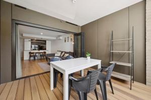 ein Esszimmer mit einem weißen Tisch und Stühlen in der Unterkunft Bright 1BR Apartment in the heart of Dickson in Downer + 13 Fotos