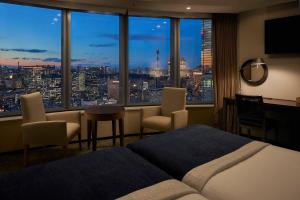 a bedroom with a view of a city skyline at Park Hotel Tokyo in Tokyo