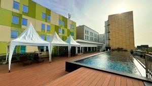 a building with a swimming pool with white tents at Swiss-Belhotel Airport Jakarta in Tangerang