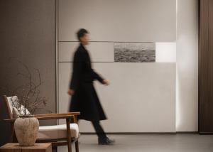 重慶市にあるWalling Hotel - Chongqing hongyadong jialingjiang binjiangluの廊下を歩いているスーツを着た男性