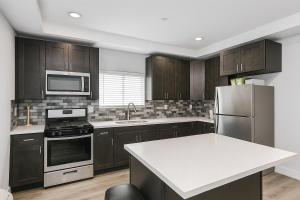 a kitchen with wooden cabinets and stainless steel appliances at Fruit Hostel in Los Angeles