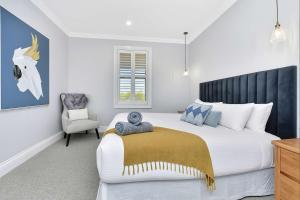 Mitchells FlatにあるStellaview Estateの大きなベッドと椅子のある寝室