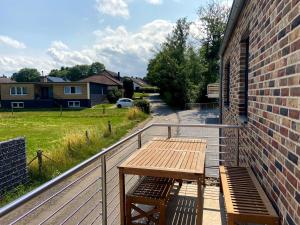 a wooden table and bench on a balcony at Wohnung In Schmidt Mit Grill Und Garten in Nideggen +8 photos