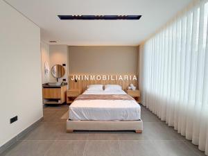 a bedroom with a bed and a large window at Apartamento de lujo a 3 minutos del Aeropuerto JMC 201 in Rionegro