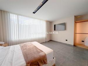 a bedroom with a bed and a flat screen tv at Apartamento de lujo a 3 minutos del Aeropuerto JMC 201 in Rionegro