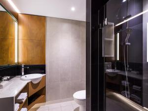 a bathroom with two sinks and a toilet at Mercure Sydney Liverpool in Liverpool