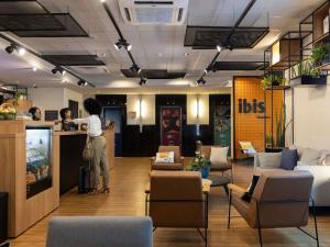 a woman standing at a counter in a lobby at Ibis Belo Horizonte Savassi in Belo Horizonte
