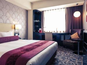 una habitación de hotel con una cama y un escritorio en Mercure Sapporo, en Sapporo 156 fotos más