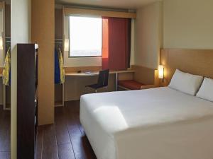 a bedroom with a bed and a desk and a window at Ibis Cancun Centro in Cancún