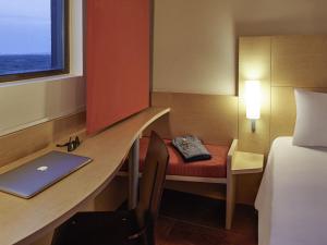 坎昆宜必思坎昆中央酒店的客房设有一张带笔记本电脑和一张床的书桌