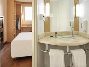 坎昆宜必思坎昆中央酒店的房间里有带水槽的浴室和一张床