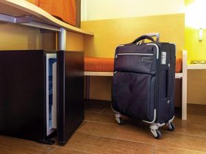 a suitcase is sitting in a room with a bed at Ibis Cancun Centro in Cancún